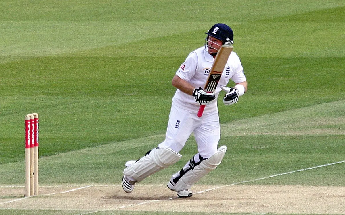 Cricket batsman playing a shot with the stumps in frame