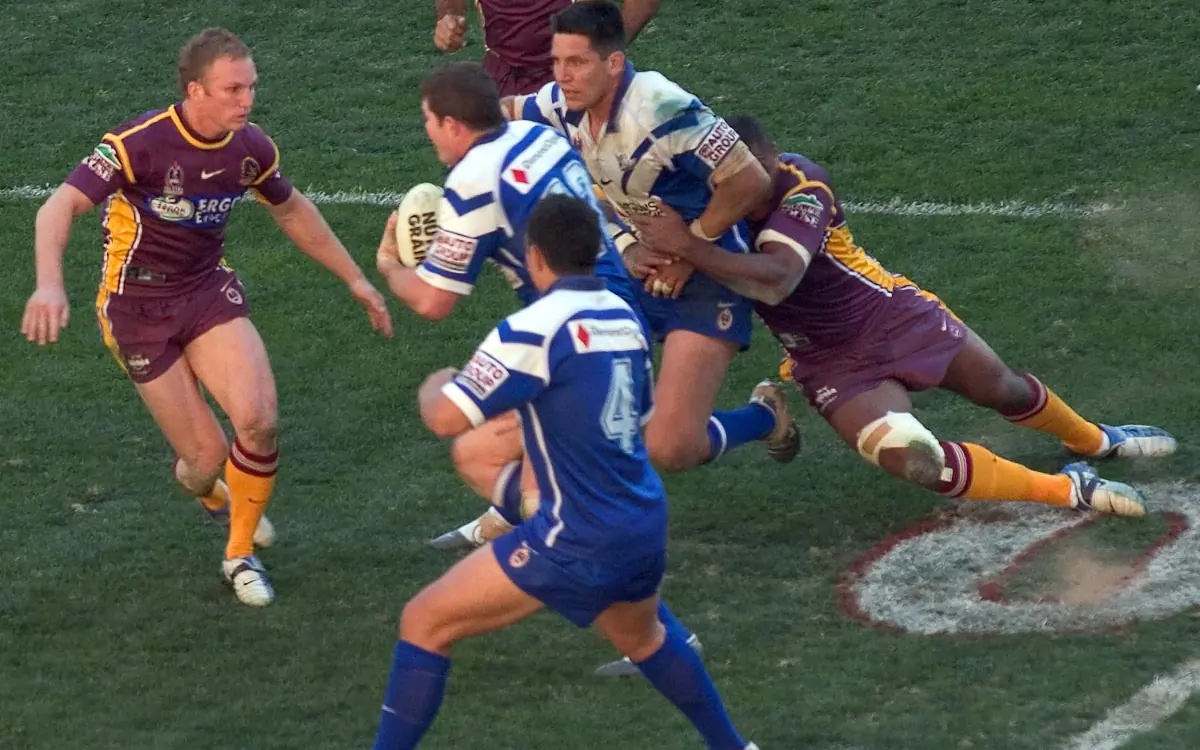 Rugby league players caught mid-tackle during an NRL match